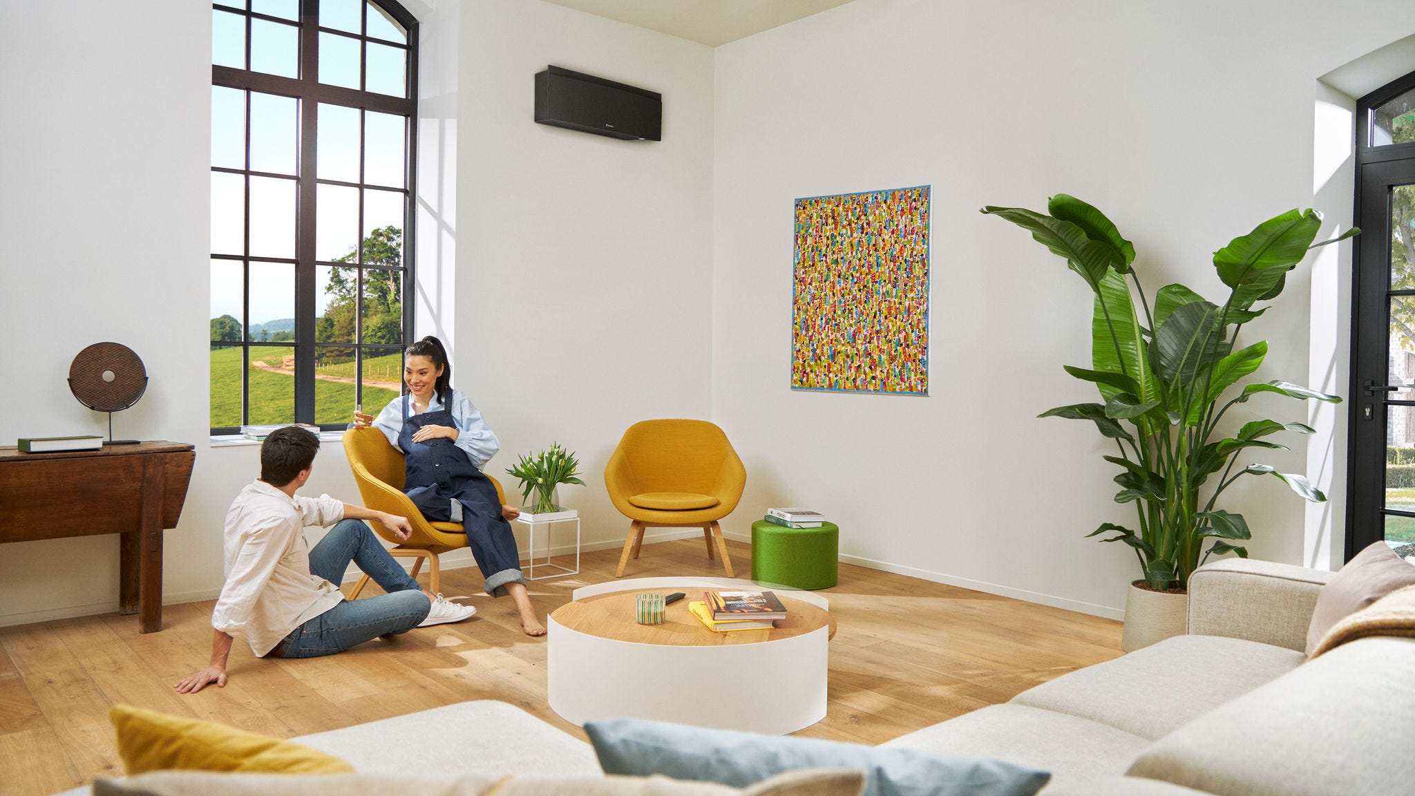 Trudnica i partner ležerno razgovaraju dok žena sjedi na stolici