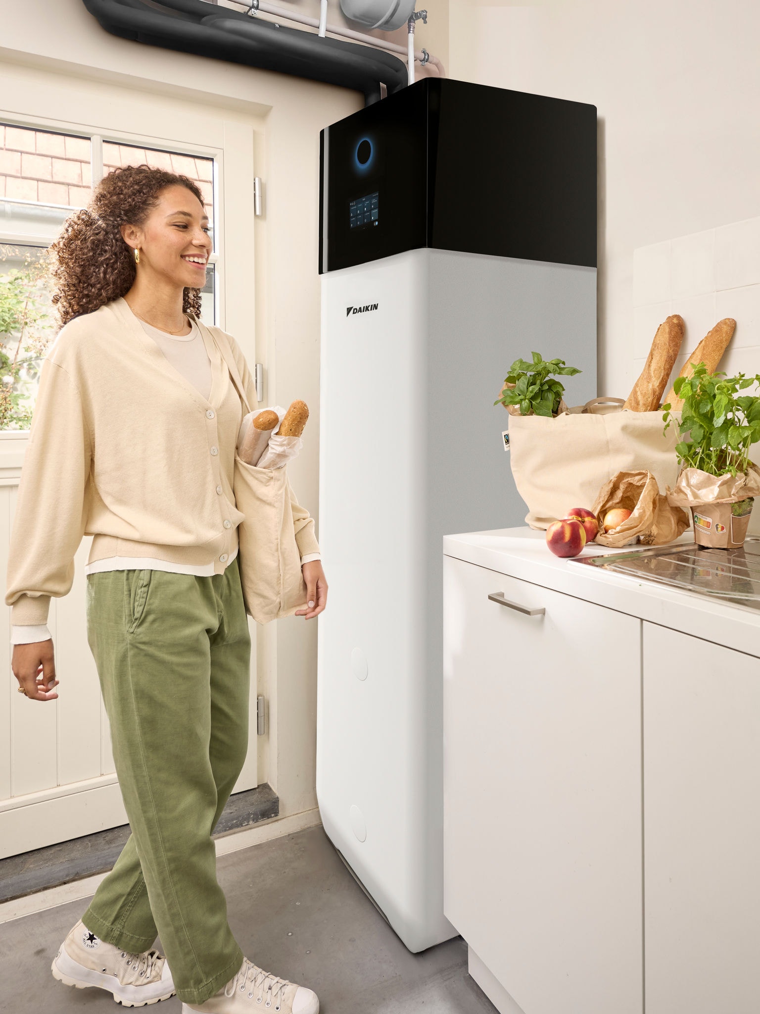 Žena se vraća kući iz kupovine, noseći vrećice sa namirnicama