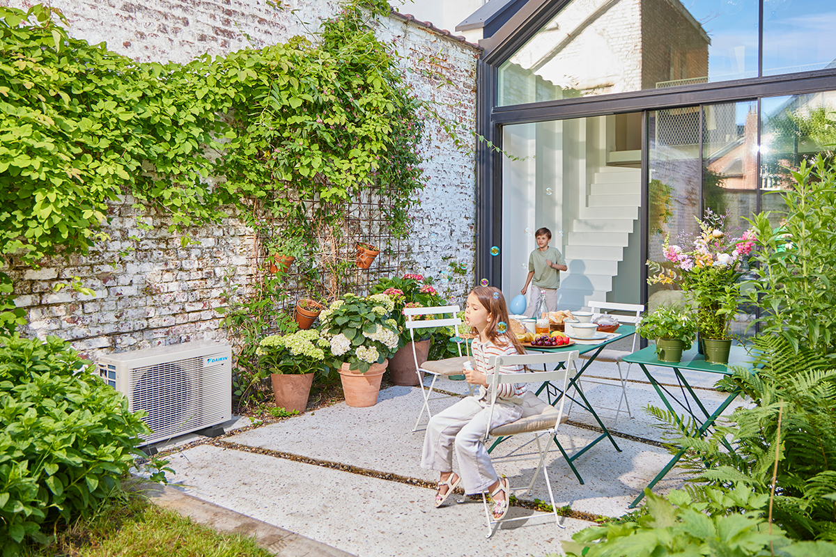 Djeca se igraju na vrtnoj terasi pored vanjske toplotne pumpe